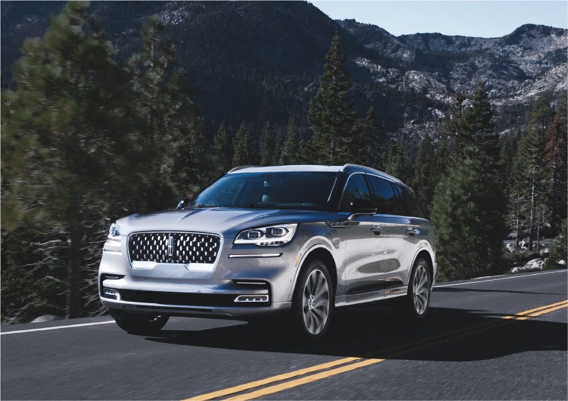 A 2023 Lincoln Aviator® Grand Touring SUV being driven on a winding road to demonstrate the capabilities of all-wheel drive | Golden Circle Lincoln in Jackson TN