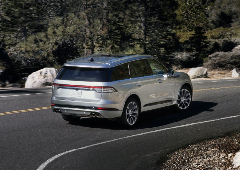 A 2023 Lincoln Aviator® Grand Touring model is shown being driven on a tight turn of a mountain road | Golden Circle Lincoln in Jackson TN