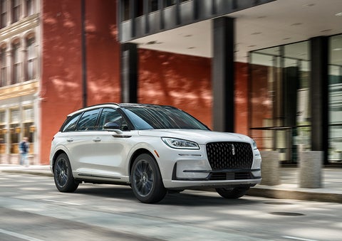 The 2024 Lincoln Corsair® SUV with the Jet Appearance Package and a Pristine White exterior is parked on a city street. | Golden Circle Lincoln in Jackson TN