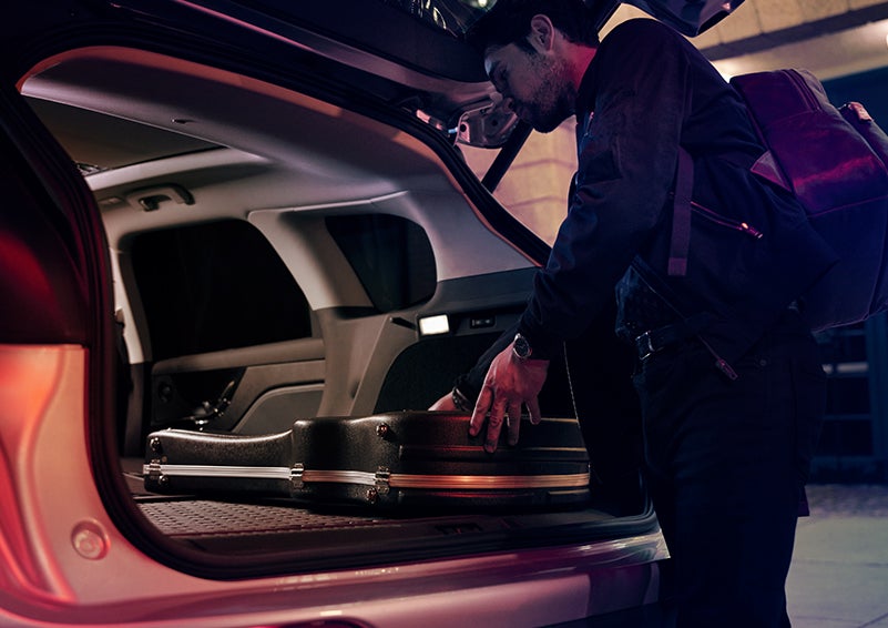 A man is shown loading cargo into the rear of a 2024 Lincoln Corsair® SUV with the second-row seats folded flat. | Golden Circle Lincoln in Jackson TN